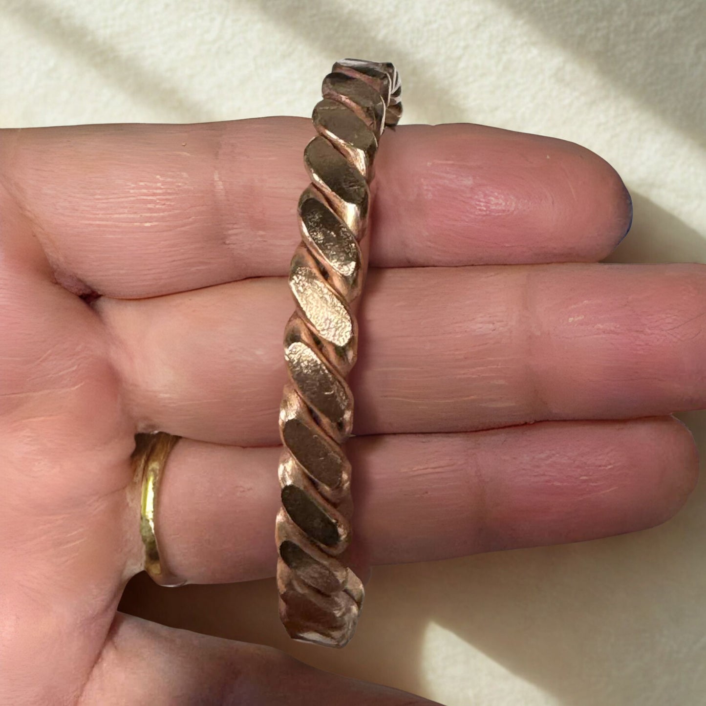 copper EMF protection bracelet on a hand against a neutral background