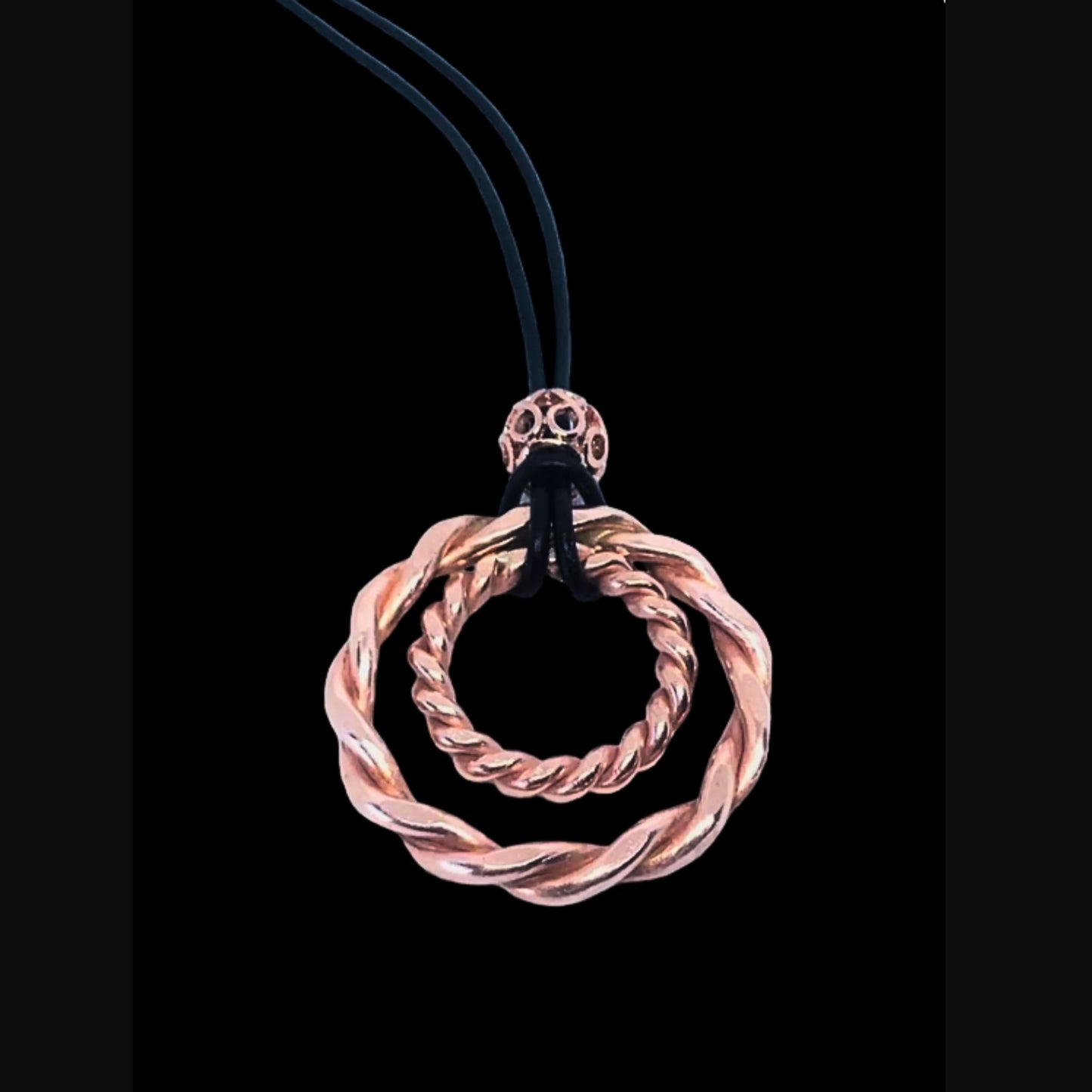 copper spiral pendant on a black background