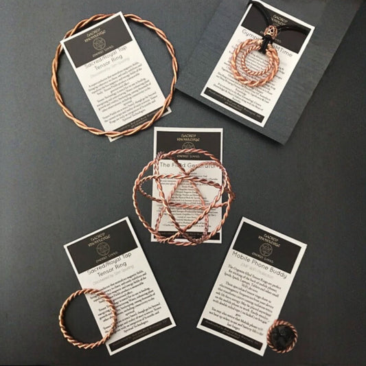 Set of copper bracelets on cards with text on a dark surface