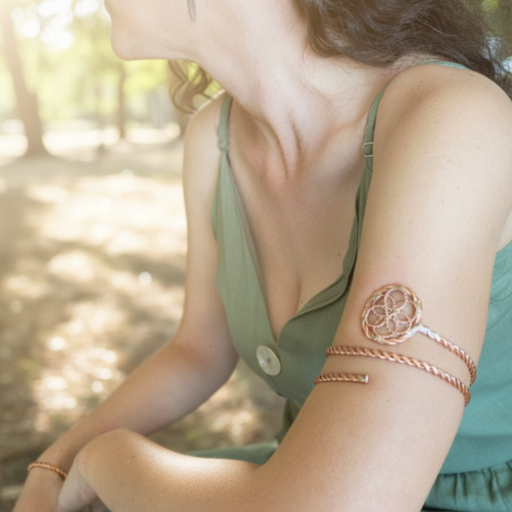 Woman wearing a green top with a button and a copper arm wrap bracelet on a white background