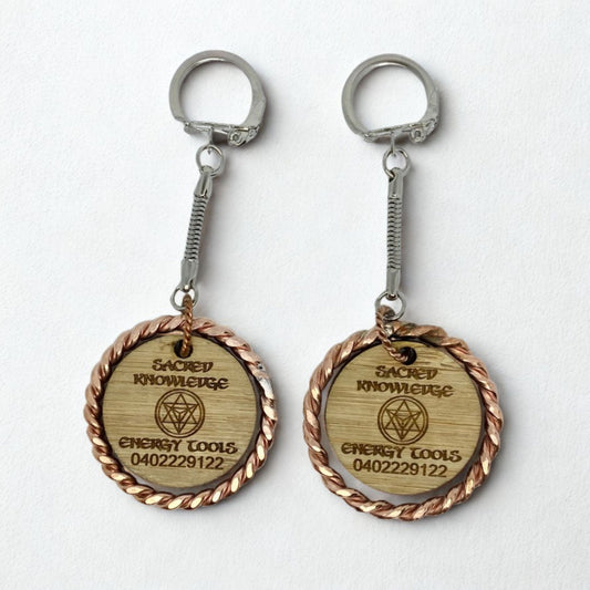 Two wooden keychains with metal loops on a white background copper EMF