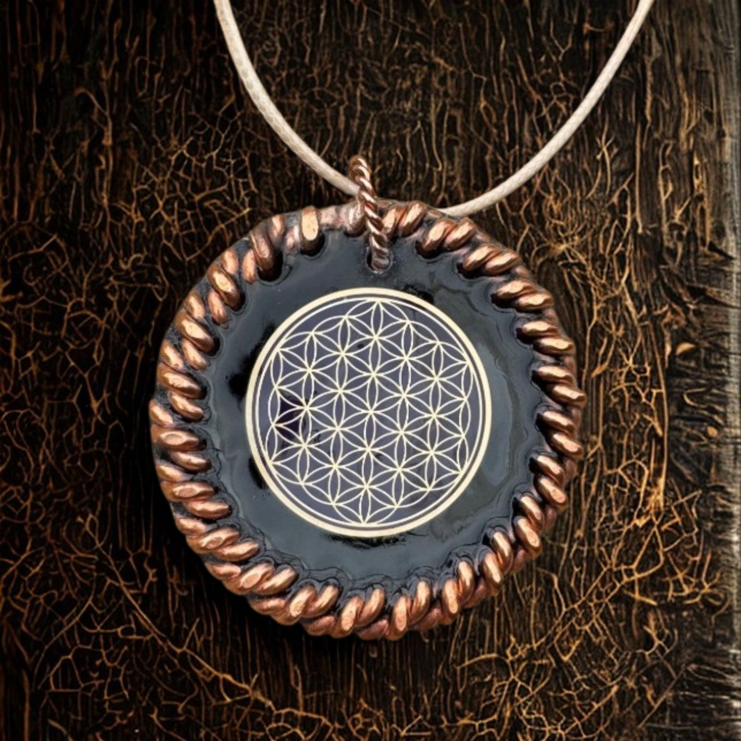 EMF Necklace with a pendant featuring a geometric design on a textured brown background