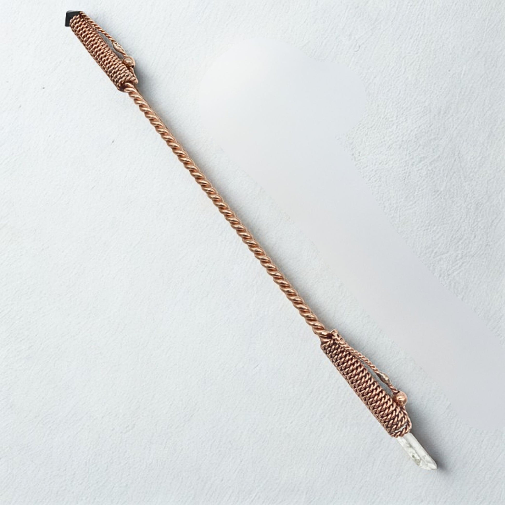 wand copper rod with a textured handle on a light gray background