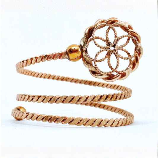Copper spiral ring with intricate design on a white background