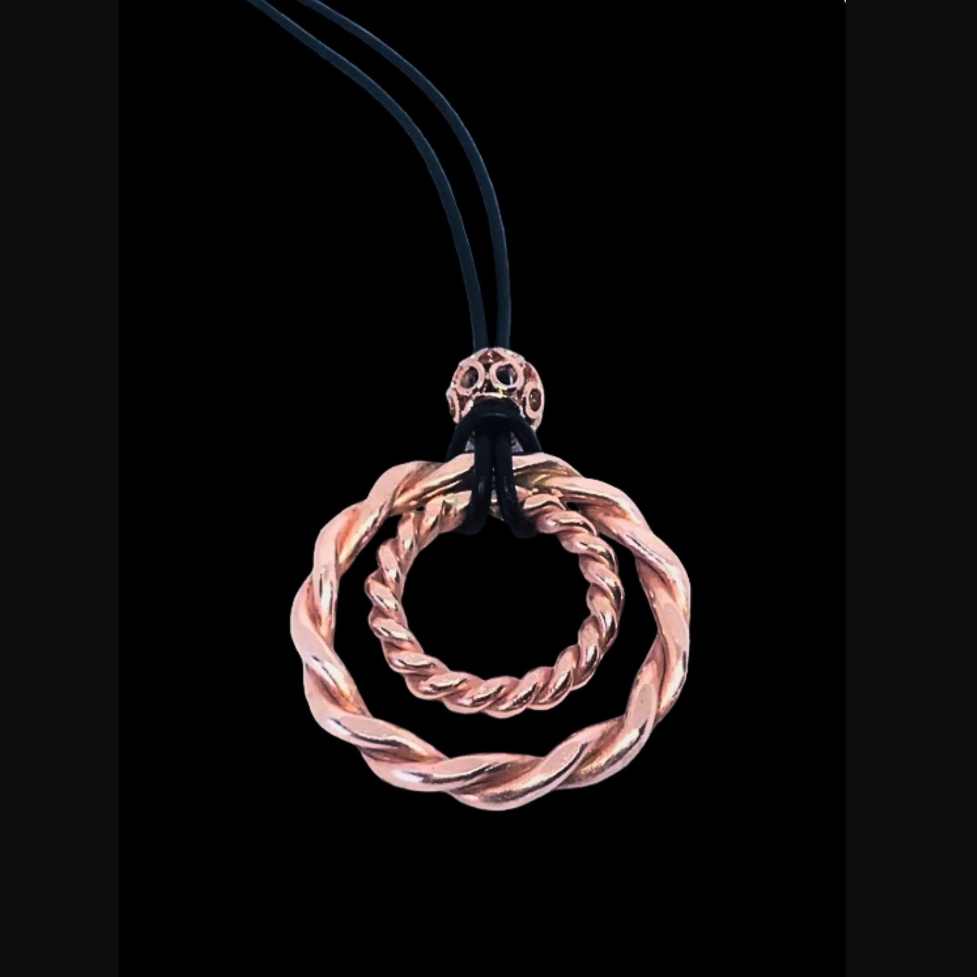 copper spiral pendant on a black background