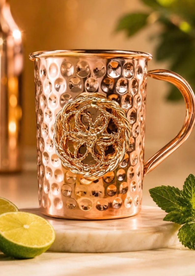 Copper mug with tensor technology on a wooden surface with limes and leaves.