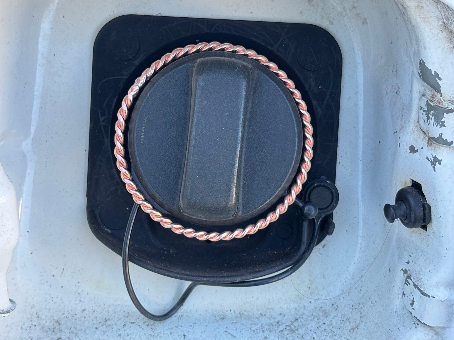 Fuel cap on a vehicle with a white background