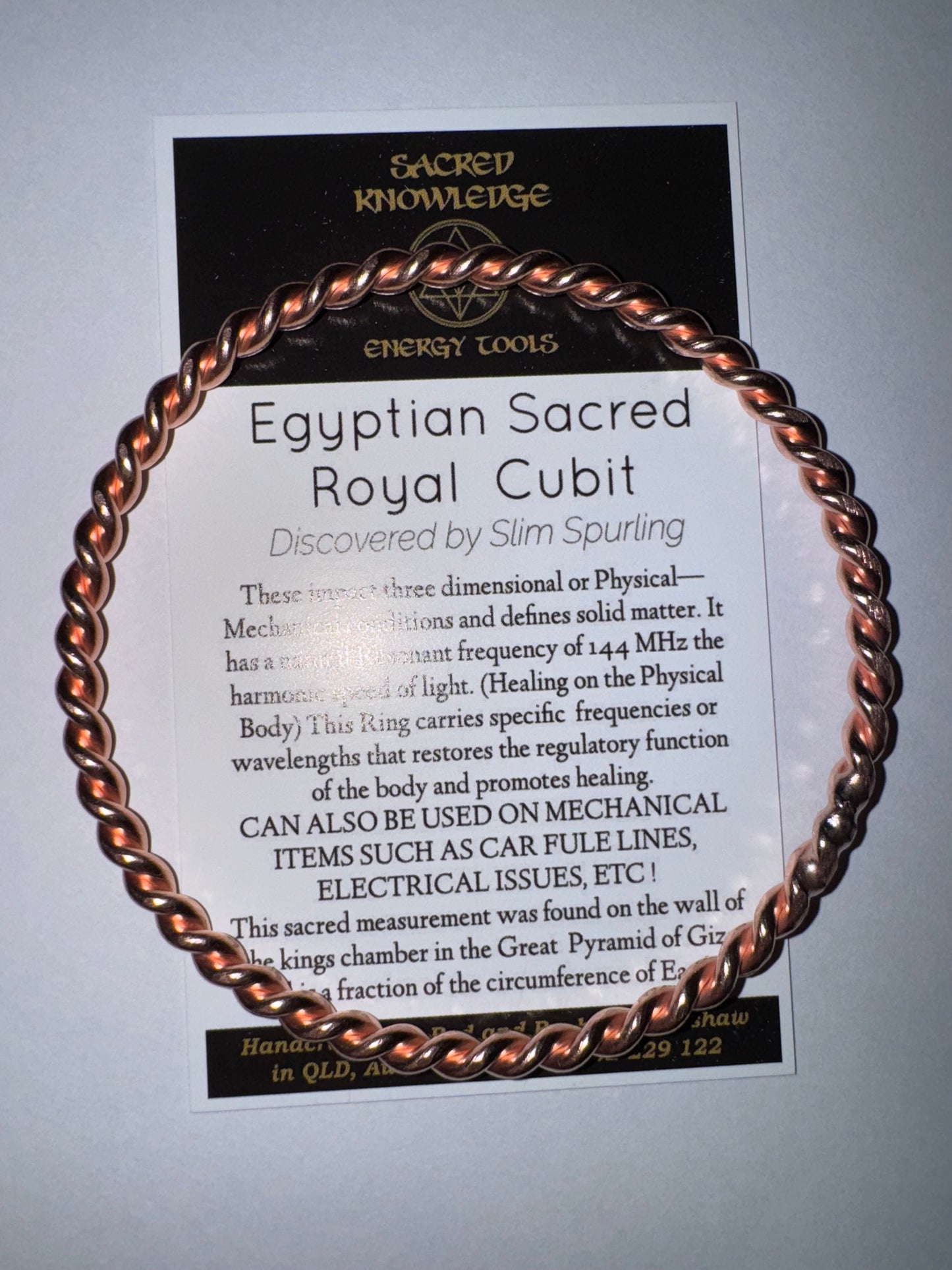 Copper bracelet on a card with text about 'Sacred Knowledge' and 'Egyptian Royal Cubit'.