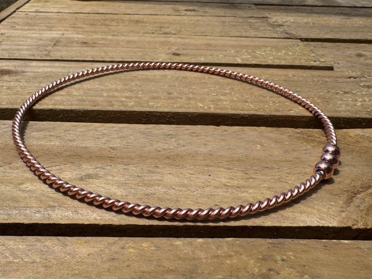 Copper ring EMF on a wooden surface