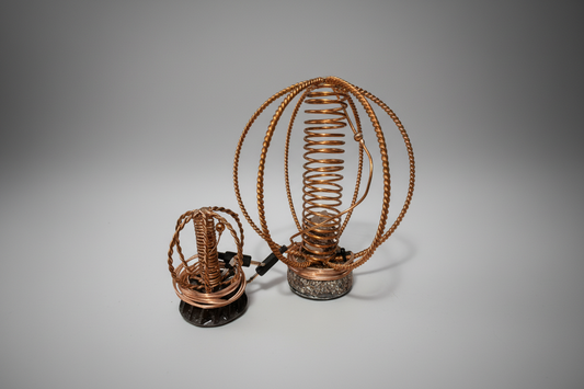copper harmonisers with coiled design on a white background